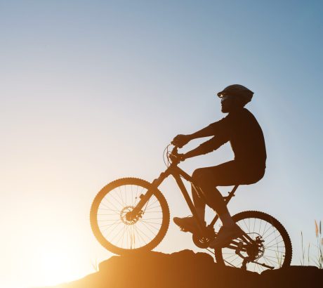 Silhouette of a man on mountain-bike during sunset.